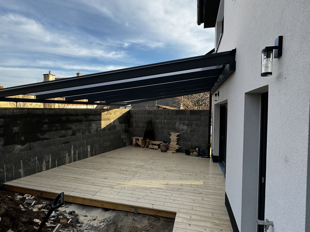 Pergola s terasou ze smrkových prken u bílého domu