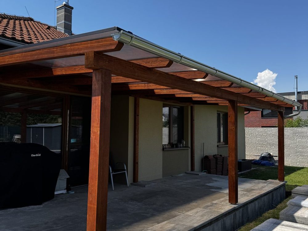 Dřevěná pergola s bronzovým polykarbonátem u přízemního domu