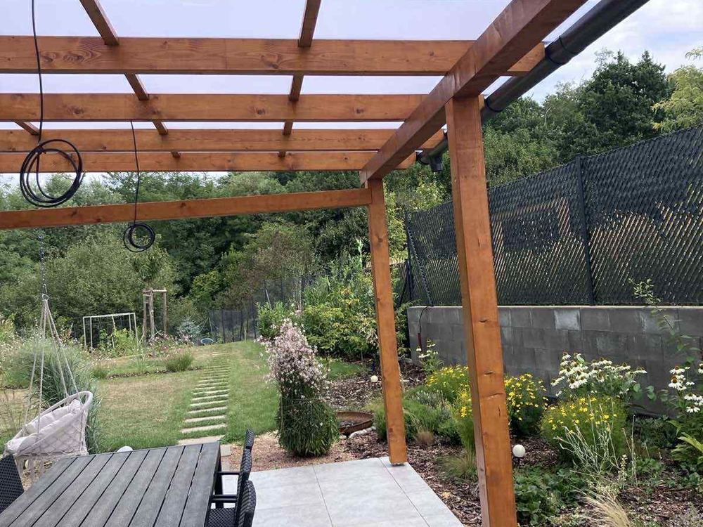 Pergola s polykarbonátovým zastřešením při pohledu od zahrady